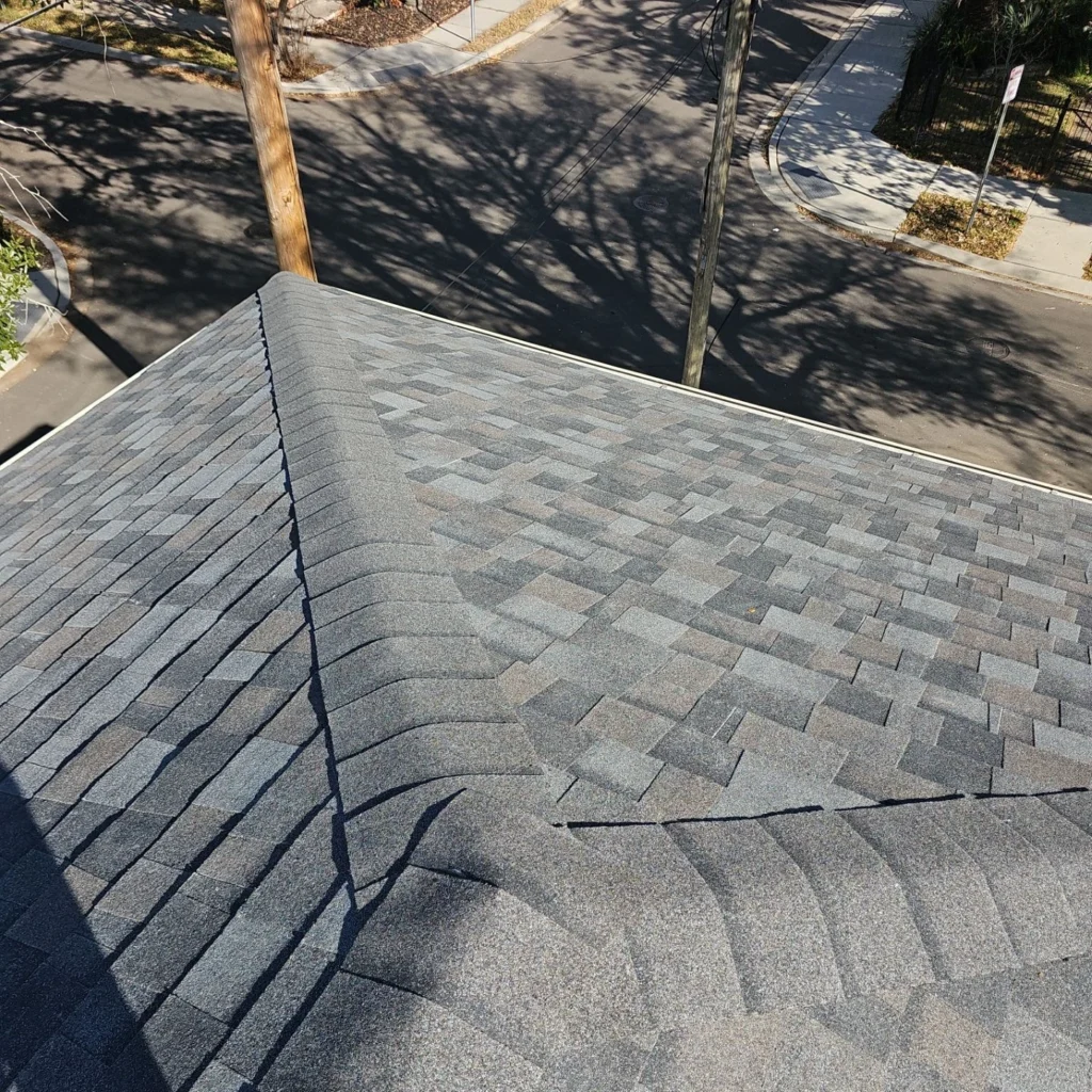 Gray Owens Corning Williamsburg architectural shingles on large FORTIFIED roof replacement, aerial corner view, Lakeview LA residential home.