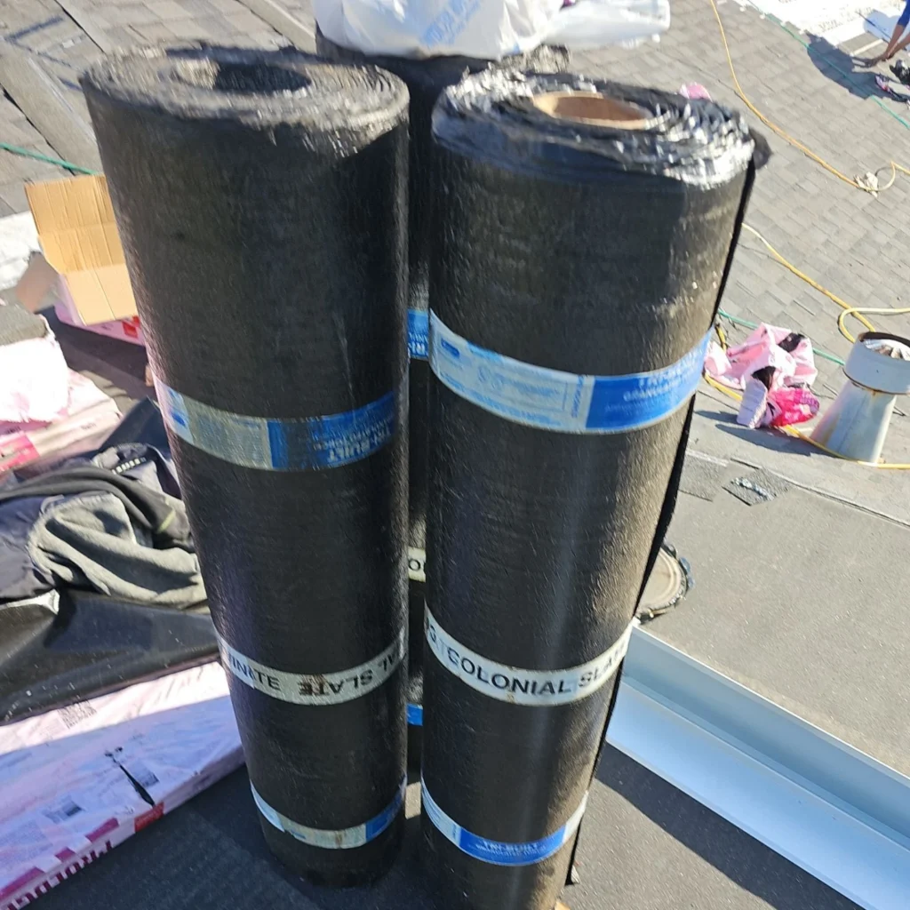 Two rolls of Owens Corning Colonial Slate roofing underlayment on a residential roof deck during a Fortified roof replacement in Lakeview, LA.