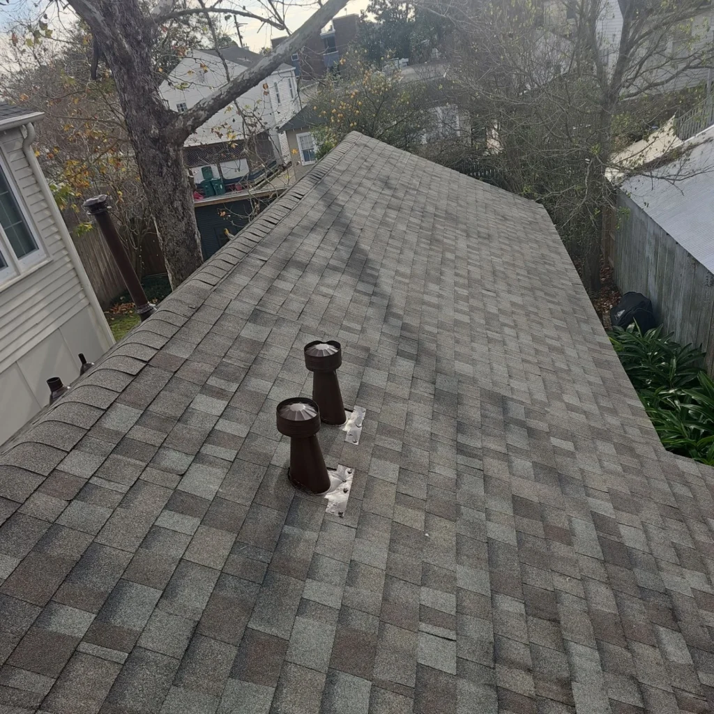 Fortified roof replacement with OC Driftwood architectural shingles and brown plumbing vent boots on French Quarter historic home.