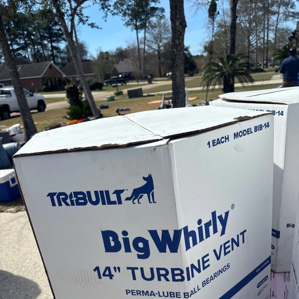 TRI-BUILT Big Whirly 14-inch turbine vents in boxes staged on driveway for large residential roof replacement in Slidell