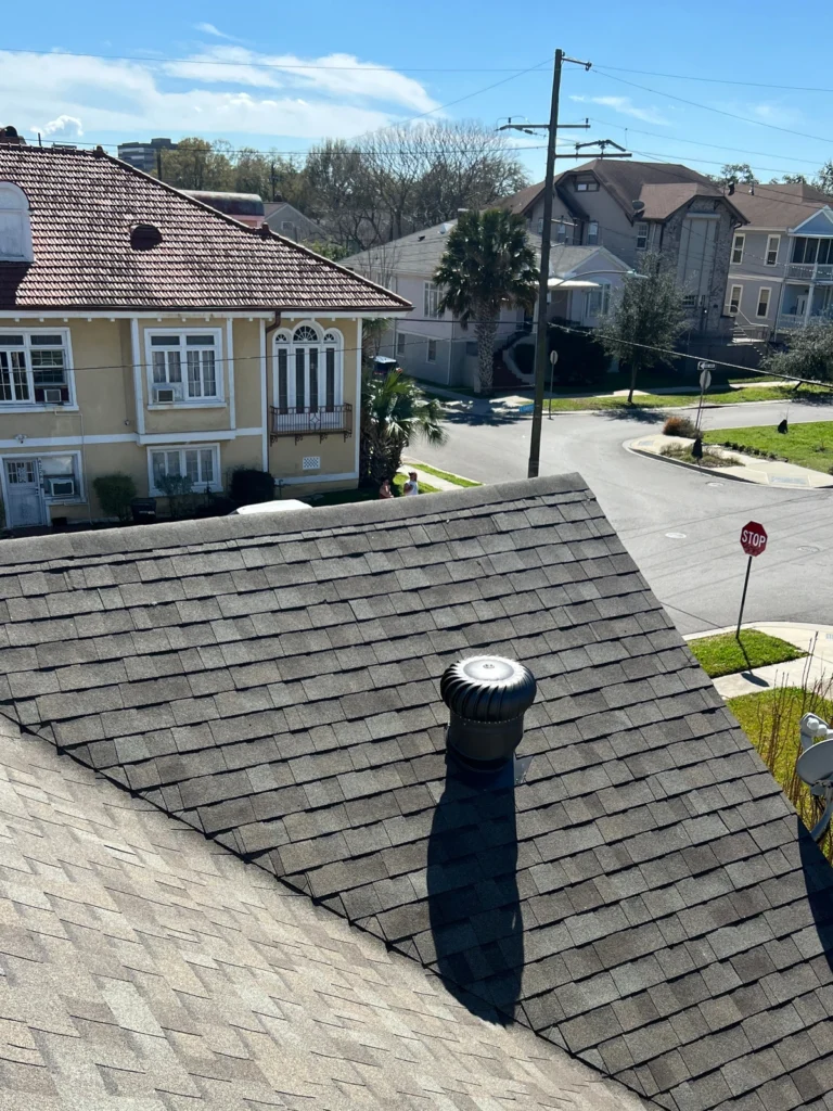 Completed large-scale residential roof replacement with Owens Corning Driftwood architectural shingles and turbine vent, Kenner neighborhood.