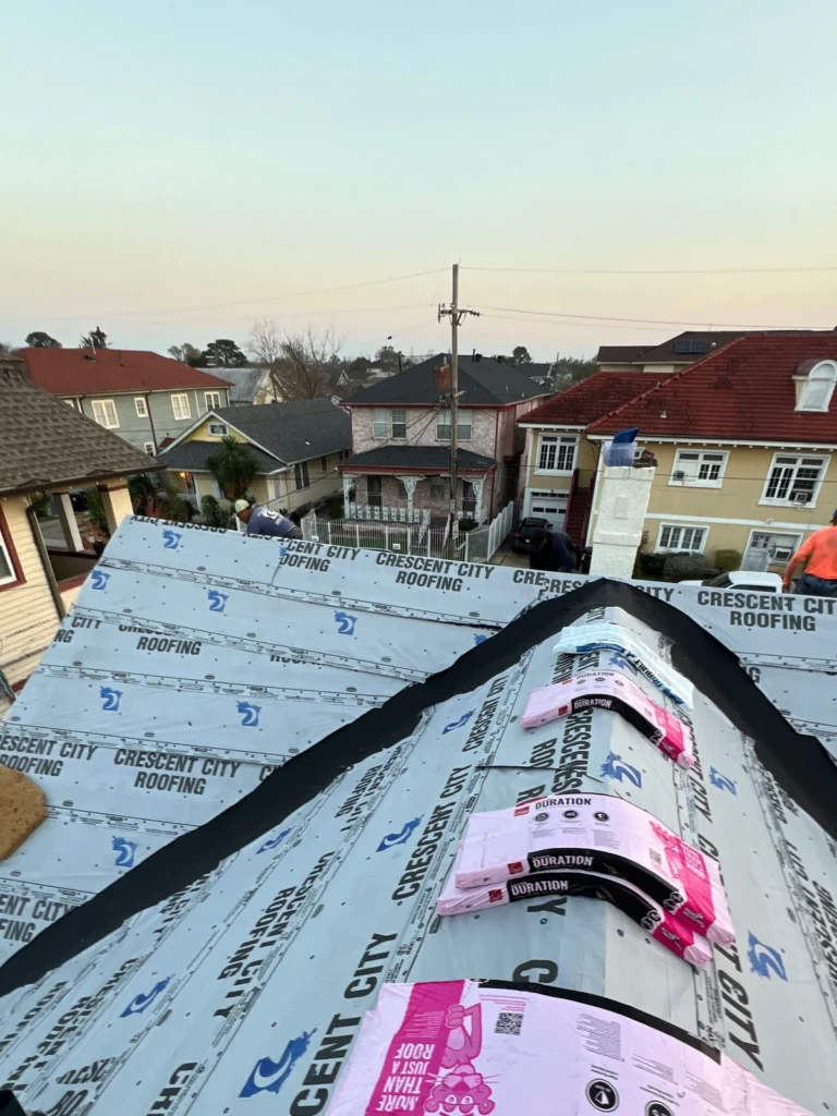 Crescent City Roofing crew installing Owens Corning Duration shingles on large residential roof in Kenner neighborhood