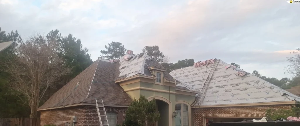 Large brick home mid-roof replacement with Crescent City Roofing underlayment installed, shingle bundles staged, ladder visible, Slidell LA