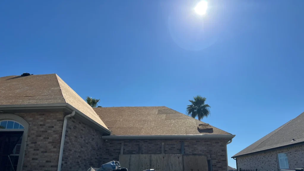 Large brick home mid-roof replacement with OC Teak Owens Corning architectural shingles installed, Slidell LA sunny day.